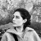 black and white headshot of Gina Onorato, a white woman with black hair wearing a cozy wool sweater